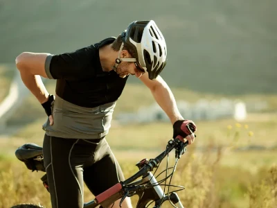 Homme ressentant des douleurs lombaires lors d'une promenade à vélo à la campagne
