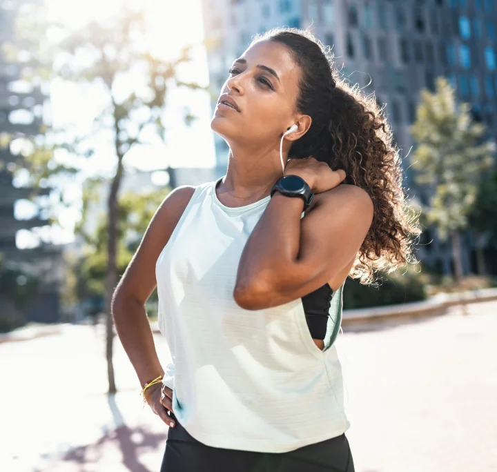 Jeune femme ressentant une douleur à l'épaule lors d'une session de course à pied