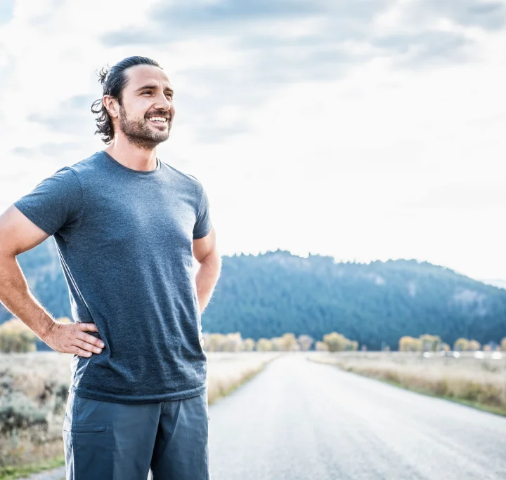 Coureur se reposant après avoir fait de l'exercice dans la campagne près des montagnes
